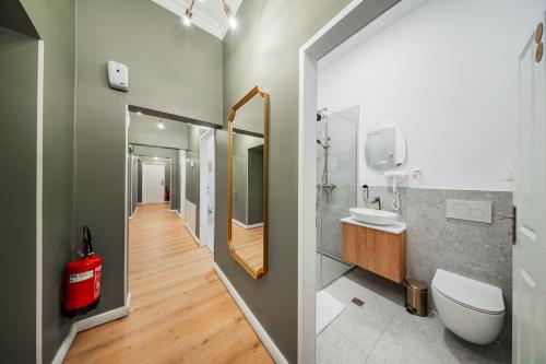 a bathroom with a toilet and a sink and a mirror at HOME1 - District Twelve Boutique Hostel in Vienna