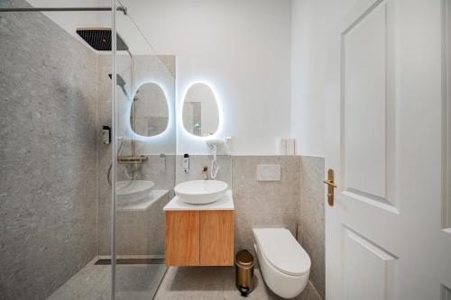 a bathroom with a sink and a toilet and mirrors at HOME1 - District Twelve Boutique Hostel in Vienna