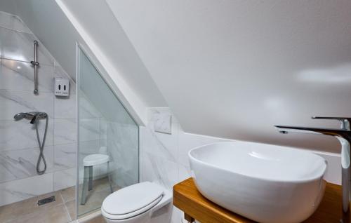 a white bathroom with a sink and a toilet at Villa 77 by Villas Guide in Sisak