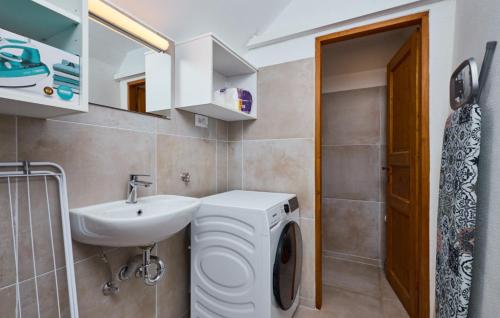 a bathroom with a washing machine and a sink at Villa 77 by Villas Guide in Sisak
