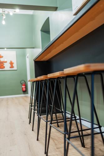 a row of stools lined up against a wall at HOME1 - District Twelve Boutique Hostel in Vienna
