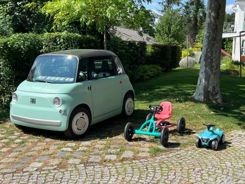 a small car and a tricycle parked next to a tree at Herrenhaus - Starnberger See - Ammerland in Münsing am Starnberger See