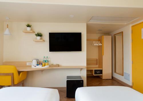 a living room with a flat screen tv on a wall at Bloom Hub WEH Andheri in Mumbai