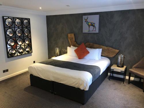 a bedroom with a large bed and a chair at Shrigley Hall Hotel in Macclesfield