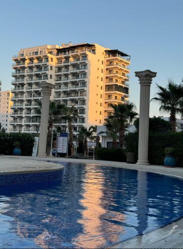 a swimming pool in front of a large building at Bedroom flat Caesar resort, Iskele north Cyprus in Vrysoules