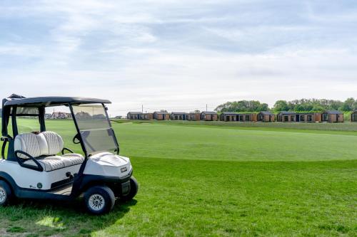 un carro de golf estacionado en un campo de hierba en Black Water Links Village, 