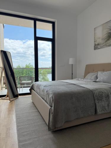 une chambre avec un grand lit et une grande fenêtre dans l'établissement Luxapartments Studio 305 Penati Golf Resort, à Šajdíkove Humence