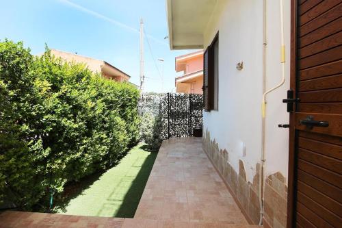 a hallway of a house with a door and bushes at Domos Sa Murta in Solanas