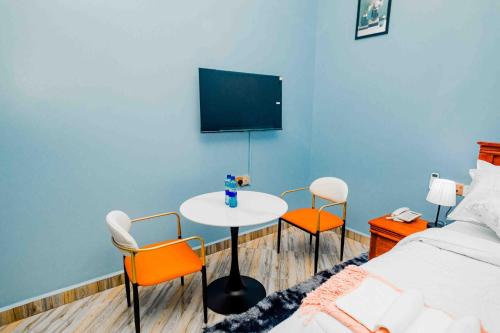 a room with a bed and a table and chairs at Joy Inn Hotel in Dar es Salaam