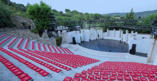 un groupe de parapluies rouges assis sur une scène dans l'établissement Charme méditerranéen Terrasse féerique et vue mer, à Ramatuelle