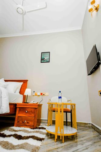 a bedroom with a yellow table and a bed at Joy Inn Hotel in Dar es Salaam