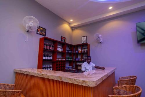 a man sitting at a bar in a room at Joy Inn Hotel in Dar es Salaam