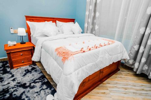 a bedroom with a large bed with a wooden headboard at Joy Inn Hotel in Dar es Salaam