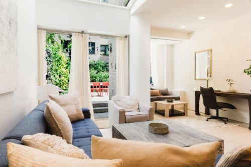 a living room with a blue couch and a table at Private Beautiful Townhome w Zen Garden in New York