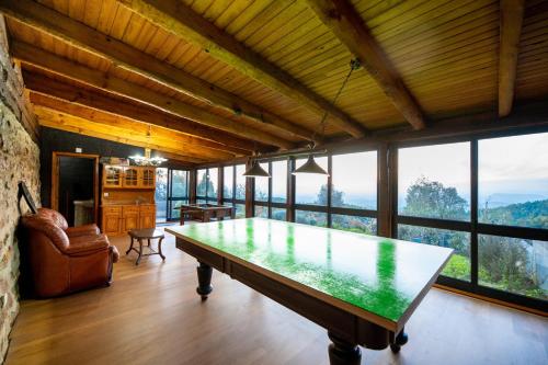 a large room with a table in front of windows at Casa da Cortiça in Figueiró dos Vinhos