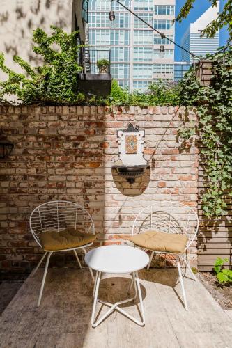 two chairs and a table in front of a brick wall at Private Beautiful Townhome w Zen Garden in New York