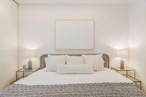 a white bedroom with a bed with two lamps at Private Beautiful Townhome w Zen Garden in New York