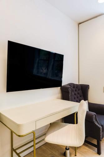 a white desk with a tv and a chair at Private Beautiful Townhome w Zen Garden in New York