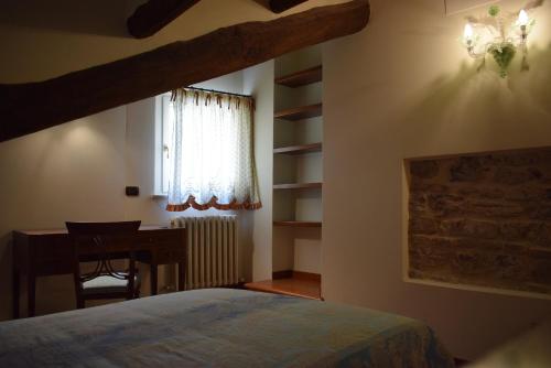 a bedroom with a bed and a desk and a window at Mazzini 16 in Perugia