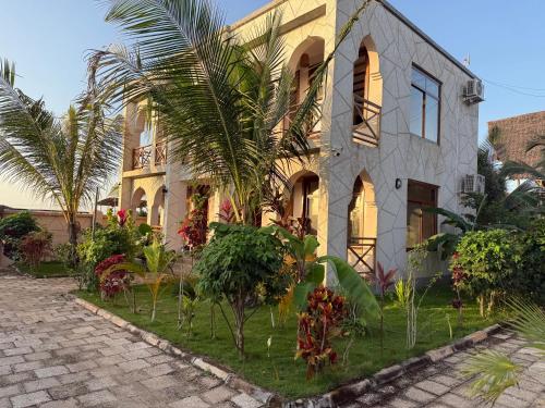 a house with palm trees in front of it at Boutique View Garden Kendwa in Kendwa