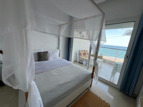 a bedroom with a bed with a view of the ocean at Mahdia front sea balcony 2 in Hiboun