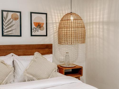 a bedroom with a bed with a lamp and a table at Kickin' Surf Lodge in Weligama