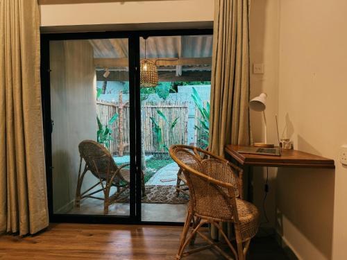 a home office with a desk and chairs and a patio at Kickin' Surf Lodge in Weligama