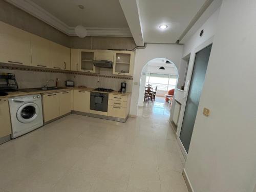 a large kitchen with a washer and dryer in it at Mahdia front sea balcony 2 in Hiboun