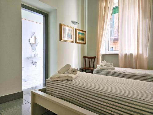a bedroom with two beds and a bathroom with a shower at Casa Terracotta in Matera