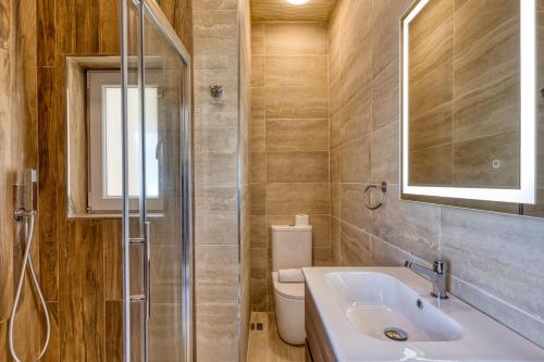 a bathroom with a sink and a toilet and a mirror at Karmnu Holiday Farmhouse in Għasri