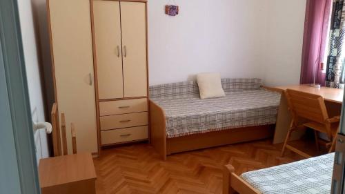 a small bedroom with a bed and a desk at Kerch Apartments in Radovići