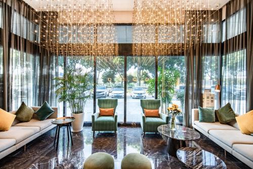 a lobby with couches and chairs and a chandelier at 深圳宝安机场碧海湾桔子水晶酒店 in Shenzhen