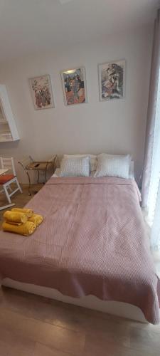 une chambre avec un grand lit avec une couverture rose dans l'établissement Summer, à Palanga