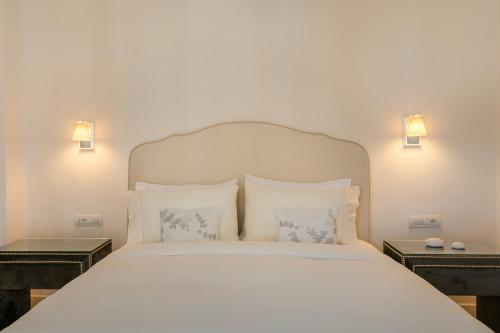 a bedroom with a white bed with two night stands at Etoile Luxury Suites in Argostoli