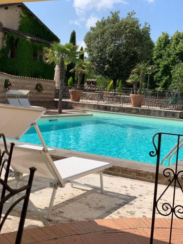 a white chair sitting next to a swimming pool at Residenza Le Querce Trilocale in Fossato di Vico