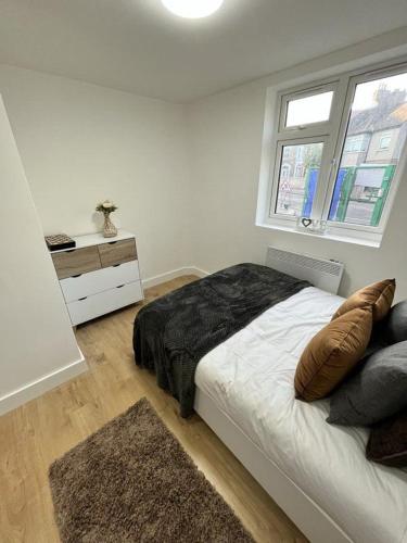 a white bedroom with a bed and a window at Cosy Double Room in Professional Unique Complex in London
