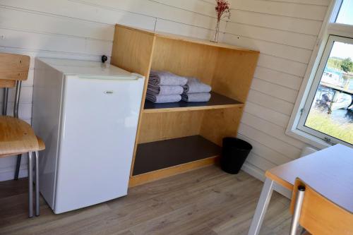a refrigerator in a small room with towels at Aalborg Hytteø in Aalborg