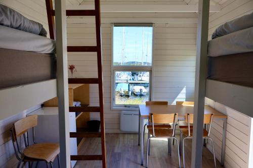 a small room with a table and chairs and bunk beds at Aalborg Hytteø in Aalborg