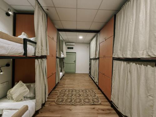 a corridor of a dorm room with bunk beds at Kickin' Surf Lodge in Weligama