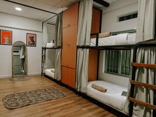 a room with three bunk beds and a wooden floor at Kickin' Surf Lodge in Weligama