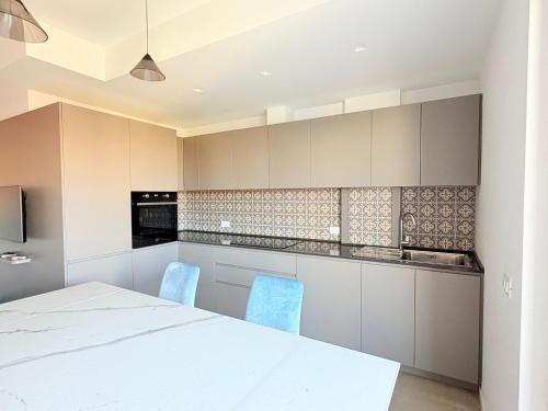 a kitchen with a white table and blue chairs at Le Dimore di Giò 515 in Ortona