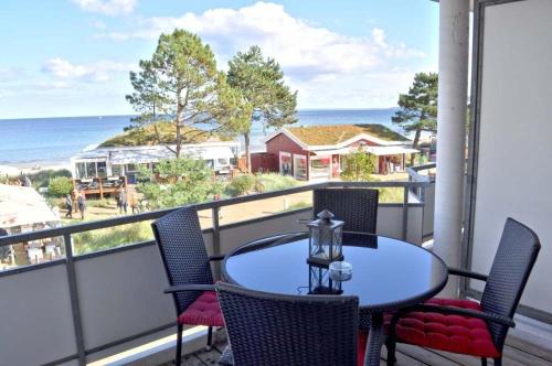 沙博伊茨Residenz Ostseestrand Ferienwohnung Nr 15 Meerblick的阳台上的桌子和椅子，可欣赏海景