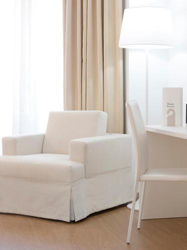 a white couch and a chair in a living room at Oliva Nova Beach & Golf Hotel in Oliva