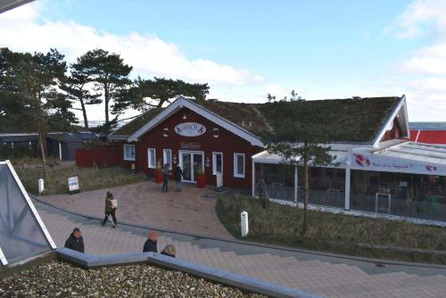 沙博伊茨Residenz Ostseestrand Ferienwohnung Nr 08的一座红色的建筑,前面的人在行走