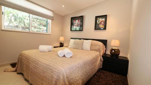 a bedroom with a bed with two towels on it at Beautiful Portuguese Villa Casa Das Buganvillas 3 Bedrooms Close To Praca Private Pool Vale Do Lobo in Vale do Lobo