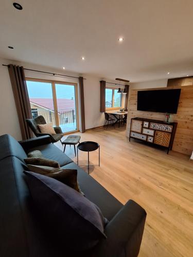 a living room with a couch and a flat screen tv at Beim Hofar - die neuen Ferienwohnungen in Obermaiselstein in Obermaiselstein