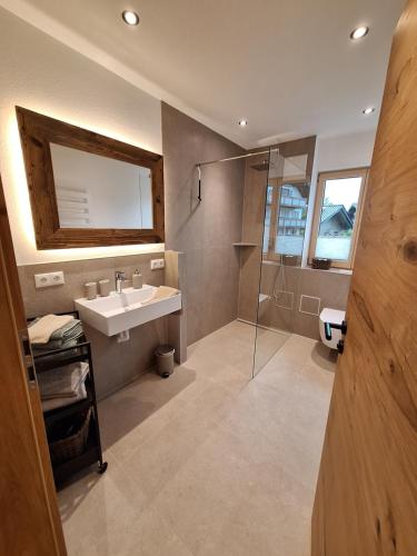 a bathroom with a sink and a shower at Beim Hofar - die neuen Ferienwohnungen in Obermaiselstein in Obermaiselstein