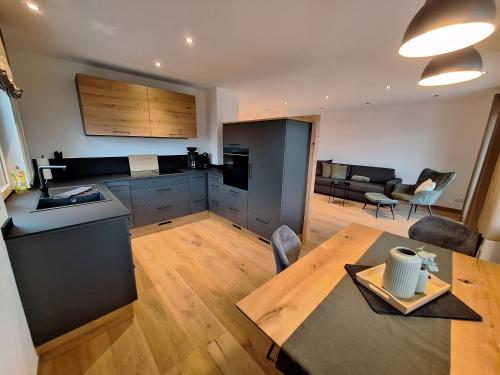 a kitchen and living room with a table and a dining room at Beim Hofar - die neuen Ferienwohnungen in Obermaiselstein in Obermaiselstein
