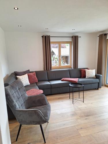 a living room with a couch and a chair at Beim Hofar - die neuen Ferienwohnungen in Obermaiselstein in Obermaiselstein