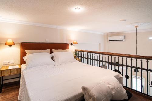 a bedroom with a large bed with white sheets and pillows at Athina Loft in Alexandroupoli